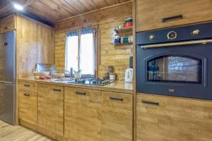 kuchnia z drewnianymi szafkami i piekarnikiem w obiekcie Sustainable Wellness House Lina - Happy Rentals w mieście Lopatinec