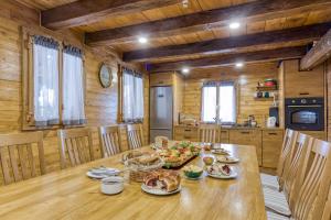 a dining room with a table with food on it at Eco House Lina With Hot Tub and Sauna - Happy Rentals in Lopatinec +24 photos