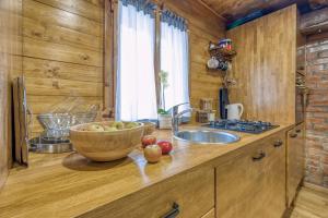 a kitchen with a bowl of fruit on a counter at Eco House Lina With Hot Tub and Sauna - Happy Rentals in Lopatinec