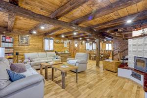 a living room with couches and a table and a tv at Eco House Lina With Hot Tub and Sauna - Happy Rentals in Lopatinec