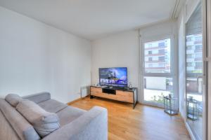 uma sala de estar com um sofá e uma televisão de ecrã plano em Casa Al Molo - Happy Rentals em Locarno
