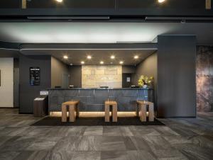 a lobby with a counter and two stools at Hotel Route-Inn Saku Minami Inter in Saku