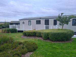 una casa con una valla blanca y un patio en Haggerston Castle , Cheviot View, en Cheswick