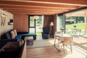 a living room with a blue couch and a table at Villa Resort & Organic Spa in České Budějovice