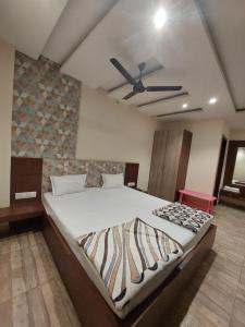 a bedroom with a large bed with a ceiling fan at HOTEL SATYAM PALACE in Deoghar