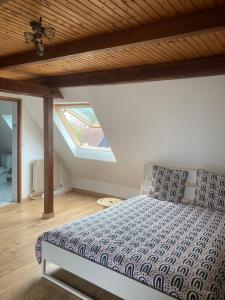 Schlafzimmer mit einem Bett mit Holzdecke in der Unterkunft Ammerschwihr le cœur du vignoble in Ammerschwihr