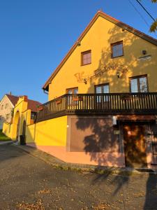 ein gelbes Gebäude mit einem Balkon an der Seite in der Unterkunft Penzion Hrádecký Dvůr in Pilsen