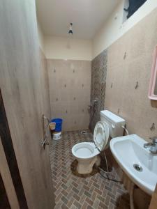 La salle de bains est pourvue de toilettes et d'un lavabo. dans l'établissement HOTEL SATYAM PALACE, à Deoghar