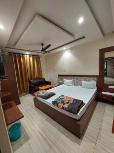 a bedroom with a bed and a couch in it at HOTEL SATYAM PALACE in Deoghar