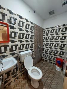 La salle de bains est pourvue de toilettes et d'un lavabo. dans l'établissement HOTEL SATYAM PALACE, à Deoghar