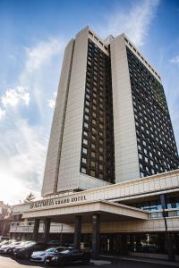 a large building with cars parked in front of it at Astoria Grand Hotel in Sofia