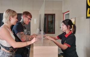 a man and a woman standing next to a counter at Ghurfati Hotel Mangga Besar in Jakarta