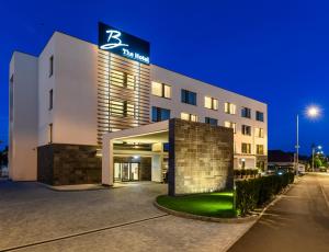 un hôtel avec un panneau sur le côté d'un bâtiment dans l'établissement B THE HOTEL, à Sfântu-Gheorghe