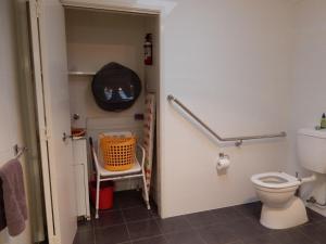 a bathroom with a toilet and an orange basket at Mariners 2 in Mollymook