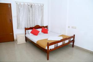 um quarto com uma cama com almofadas vermelhas e uma janela em Zion Lodge em Cochin