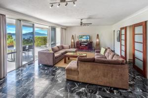 a living room with two couches and a table at 3 Bedroom Poinciana Lodge in Hamilton Island