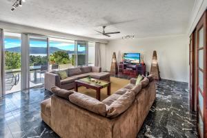 a living room with a large couch and a television at 3 Bedroom Poinciana Lodge in Hamilton Island