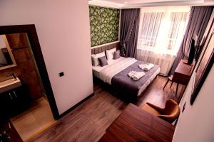 Dormitorio pequeño con cama y espejo en Hotel Yaman, en Eberswalde-Finow