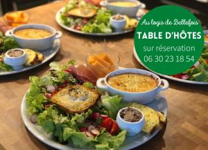 uma mesa coberta com pratos de alimentos com pratos de alimentos em AU LOGIS DE BELLEFOIS - Chambres d'hôtes em Neuville-du-Poitou
