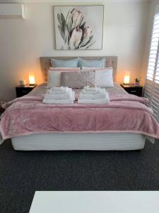 Una cama grande con dos toallas blancas. en Large relaxing light filled room in Bowral, en Bowral