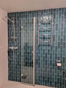 uma casa de banho com um chuveiro com azulejos de vidro verde em Apartment with two bedrooms and a parking space em Vantaa