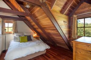 a bedroom with a bed in a room with wooden walls at Stone Cottage in Milton