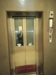 un ascensor en un edificio con una persona en el reflejo en Hotel Joshi en Bhairāhawā