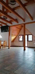 Habitación grande con techos de madera y vigas de madera. en Casa Diana Rasnov en Rîşnov