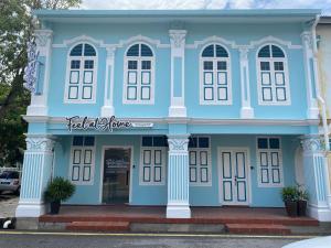 a blue building with white columns at Homestay "Feel at Home" Near A Famosa & Jonker Street for 4-7 people in Melaka
