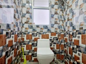 a bathroom with a toilet and a wall of tiles at Neoravalley Homestay, Lava in Rishop