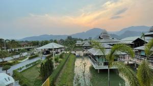 uma vista para um resort com um rio e edifícios em Vathanagul Resort em Chiang Rai