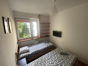 sypialnia z 2 łóżkami i oknem w obiekcie Pokoje Bora-Komorowskiego w Warszawie
