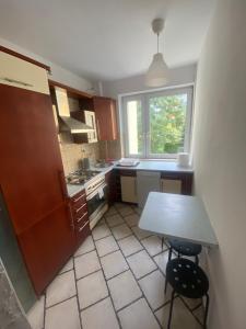 a small kitchen with a table and a window at Pokoje Bora-Komorowskiego in Warsaw