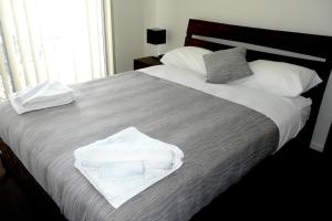 Un dormitorio con una cama con toallas blancas. en Monterey Apartments Moranbah en Moranbah