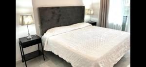 a bedroom with a white bed with two lamps on tables at Mi Capricho 2B1 Beachfront Complex-Apartment Beachside With sea views in Mijas Costa