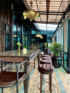 uma sala de jantar com uma mesa longa e bancos em Vathanagul Resort em Chiang Rai