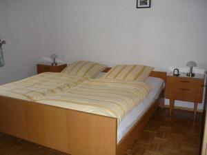 Ce lit se trouve dans une chambre dotée d'une table de chevet et d'une table de chevet. dans l'établissement Ferienwohnung Oehlert, à Großsolt