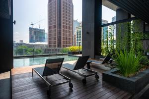 a balcony with chairs and a view of a city at Anggun Residences Luxe in Kuala Lumpur