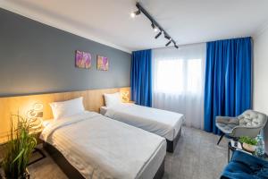 ein Hotelzimmer mit 2 Betten und einem Stuhl in der Unterkunft Campeador Inn in Cluj-Napoca
