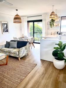 a living room with a couch and a kitchen at THE DAVEY Luxury home in Nambucca Heads