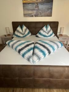 a bed with blue and white pillows on it at Appartement Petra in Bruck an der Großglocknerstraße