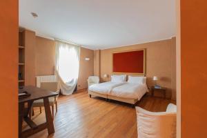 Hotel Cristallo في ألانيا فالسيزيا: غرفة نوم بسرير ومكتب وطاولة