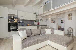 Villetta a Mare في أولبيا: غرفة معيشة مع أريكة ومطبخ