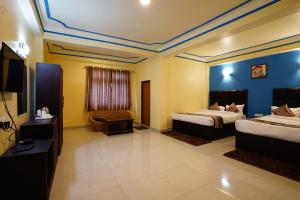 Habitación de hotel con 2 camas y TV de pantalla plana. en Hotel White Lotus Gangtok en Gangtok