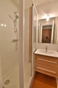 a white bathroom with a sink and a shower at CONFORTABLE APPARTEMENT GRANDE TERRASSE PISCINE PARKING CLIM in Cap d'Agde
