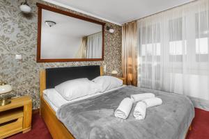 sypialnia z dużym łóżkiem z dwoma ręcznikami w obiekcie Holiday Stary Folwark w mieście Suwałki