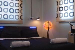 sypialnia z czarnym łóżkiem i lampką w obiekcie Deluxe οροφοδιαμέρισμα με υδρομασάζ κ' ταρατσόκηπο w mieście Patras