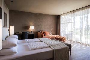 a bedroom with a large bed and a large window at ADLER Spa Resort SICILIA in Siculiana