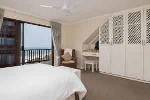 een slaapkamer met een wit bed en een balkon bij Martinique 18 in Ballito