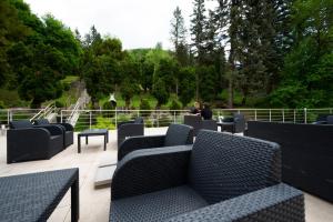 特倫欽溫泉鎮的住宿－Hotel DSZSU，两人坐在带蓝色椅子的庭院